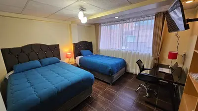 a bedroom with a bed and a desk and a television at Casa Independiente muy cerca al centro historico - Los Profesionales in Cusco