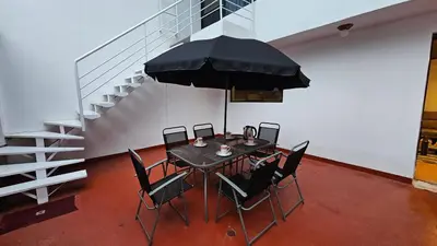 a dining room with a table with chairs and an umbrella at Casa Independiente muy cerca al centro historico - Los Profesionales in Cusco