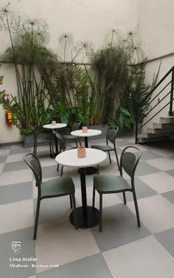 a group of tables and chairs in a room with plants at Lima Atelier Boutique in Lima