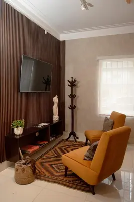 a living room with an orange chair and a tv at Lima Atelier Boutique in Lima