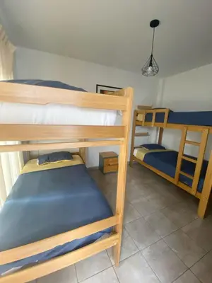 a room with three bunk beds in a house at Ravenala Paracas Hostel & Apartment in Paracas