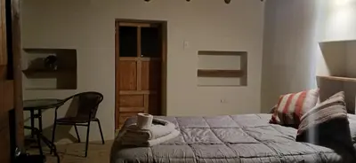 a bedroom with a bed and a table and a chair at HOSTEL INKA PACCHA - cascada inka in Ollantaytambo