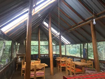 a room with wooden tables and chairs in a tent at HOSTEL INKA PACCHA - cascada inka in Ollantaytambo