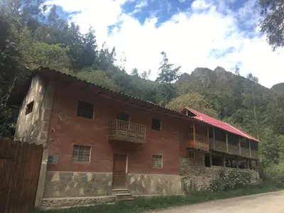 a red building with balconies on the side of it at HOSTEL INKA PACCHA - cascada inka in Ollantaytambo