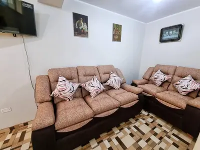 a living room with two brown couches with pillows on them at Apartamento amplio y acogedor in Huancayo