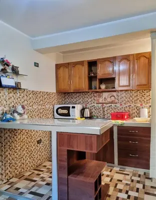 a kitchen with wooden cabinets and a counter top at Apartamento amplio y acogedor in Huancayo