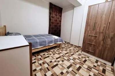 a small room with a bed and a kitchen at Apartamento amplio y acogedor in Huancayo