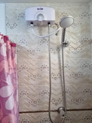 a shower in a bathroom with a scale on the wall at Apartamento amplio y acogedor in Huancayo