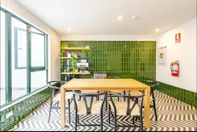 a table and chairs in a room with green tiles at Cómodo y silencioso Apartamento 1BR en Barranco in Lima