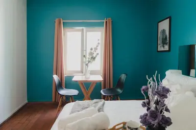 a bedroom with blue walls and a table and chairs at Casa Bellido - Miraflores Private Rooms - Cocina Compartida - Wifi in Lima