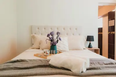 a bedroom with a white bed with a vase of flowers at Casa Bellido - Miraflores Private Rooms - Cocina Compartida - Wifi in Lima