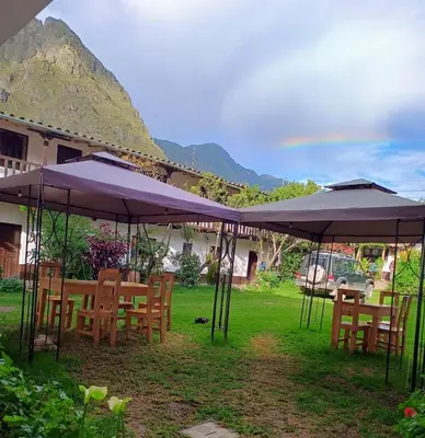 a group of tables and chairs under umbrellas at Sequeiros Garden in Ollantaytambo