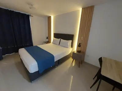 a bedroom with a large bed with a blue blanket at Mandala Lux Hotel in Pisco