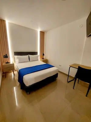 a bedroom with a large bed and a desk at Mandala Lux Hotel in Pisco