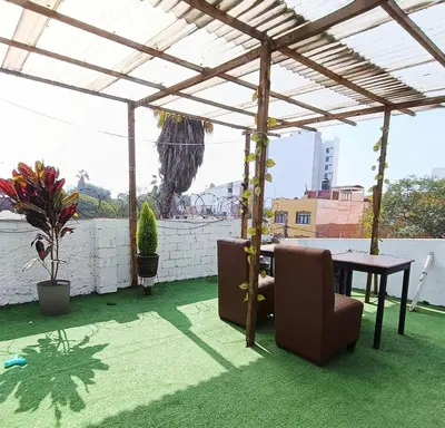 a patio with a table and chairs under a canopy at Casona Turística Gonzales in Lima