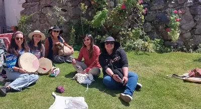 a group of women sitting on the grass at Hostal Miramonti in Urubamba