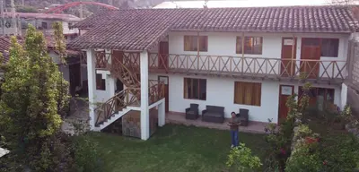 a person standing in front of a house at Hostal Miramonti in Urubamba