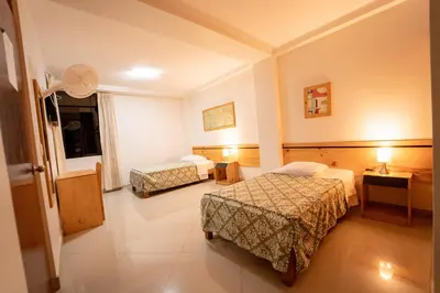 a hotel room with two beds and a window at Hostal Los Balcones in Nazca