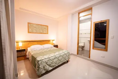 a hotel room with a bed and a bathroom at Hostal Los Balcones in Nazca