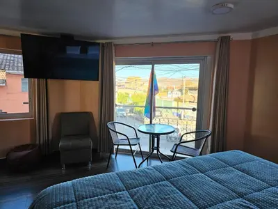 a bedroom with a bed and a table and chairs and a window at Hospedaje Paqcha in Cusco