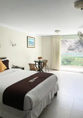 a bedroom with a bed and a table and a window at Villasol Hotel in Lunahuaná