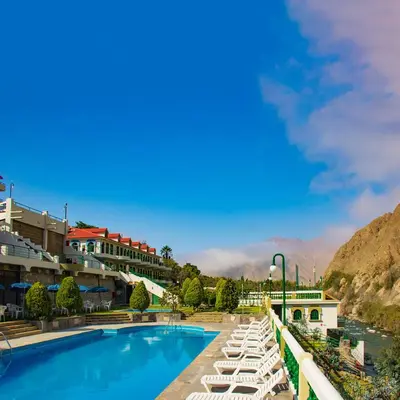 a resort with a swimming pool and lounge chairs at Villasol Hotel in Lunahuaná