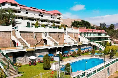 a hotel with a swimming pool in front of a building at Villasol Hotel in Lunahuaná