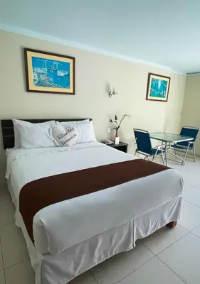 a bedroom with a large bed and a table at Villasol Hotel in Lunahuaná