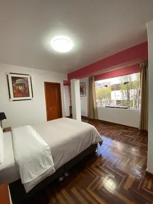 a bedroom with a bed and a large window at Plaza del Inka in Cusco