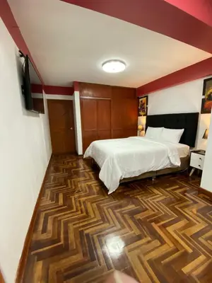 a bedroom with a bed and a wooden floor at Plaza del Inka in Cusco