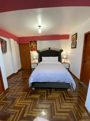 a bedroom with a large bed and two night stands at Plaza del Inka in Cusco