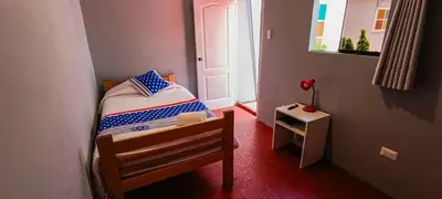 a small bedroom with a bed and a small table at Les Sorciers ooo in Cusco
