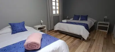 a bedroom with two beds with blue and white sheets at Les Sorciers ooo in Cusco