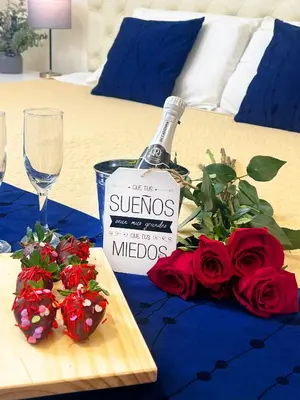 a bottle of wine and red roses on a table at Rig Vêda Hotel in Lima