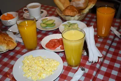 a table with plates of food and glasses of orange juice at Casablanca Lima in Lima