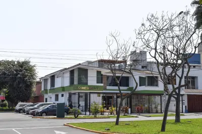 a building on a street with cars parked in a parking lot at Casablanca Lima in Lima
