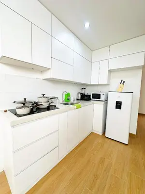 a white kitchen with white cabinets and a refrigerator at El Oasis de Huacachina - Alojamiento in Ica