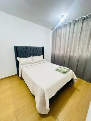a bedroom with a bed with a black headboard at El Oasis de Huacachina - Alojamiento in Ica