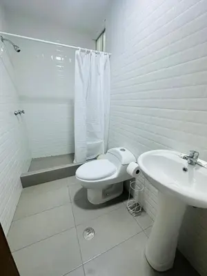 a white bathroom with a toilet and a sink at El Oasis de Huacachina - Alojamiento in Ica