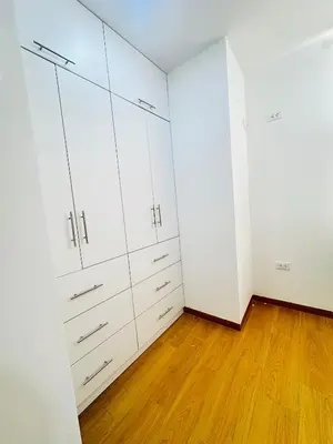 an empty room with white cabinets and wood floors at El Oasis de Huacachina - Alojamiento in Ica