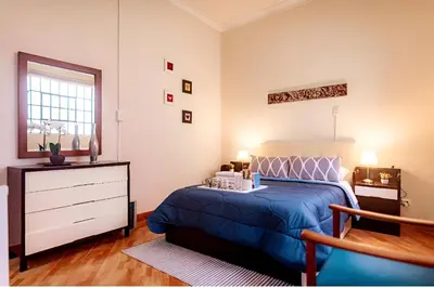 a bedroom with a blue bed and a dresser at Tripper Monkey House Miraflores in Lima