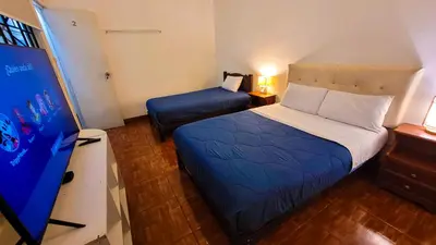 a bedroom with a bed and a tv in a room at Tripper Monkey House Miraflores in Lima