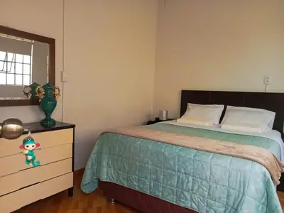 a bedroom with a bed and a dresser and a window at Tripper Monkey House Miraflores in Lima