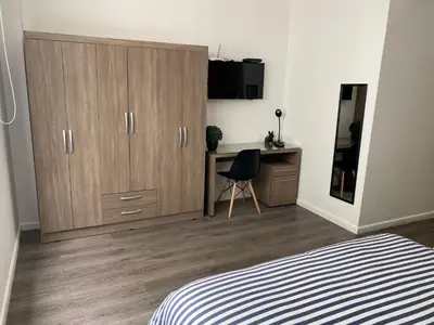 a bedroom with a desk and a large wardrobe and a bed at Enjoy Lima in a Renovated and Private Apt D in Lima