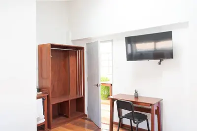 a room with a desk and a television on a wall at Solara Art House Hotel in Cusco