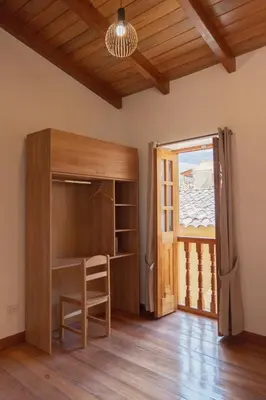 a room with a desk and a sliding glass door at Casa Alba Ollantaytambo in Ollantaytambo