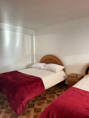 a bedroom with two beds with red and white sheets at IntiKilla in Mollepata