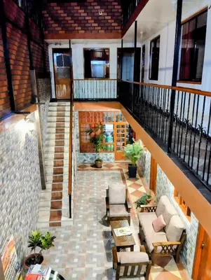 a room with a staircase with chairs and tables at IntiKilla in Mollepata
