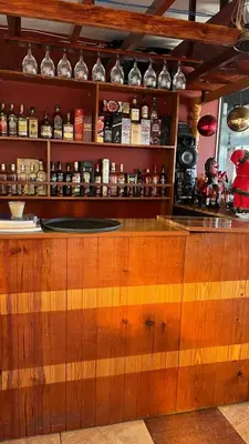 a bar with a wooden counter with bottles of alcohol at IntiKilla in Mollepata