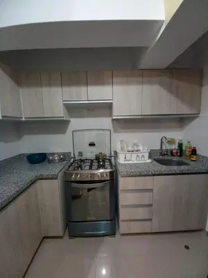 a small kitchen with a stove and a sink at Casa Linda San Miguel in Lima